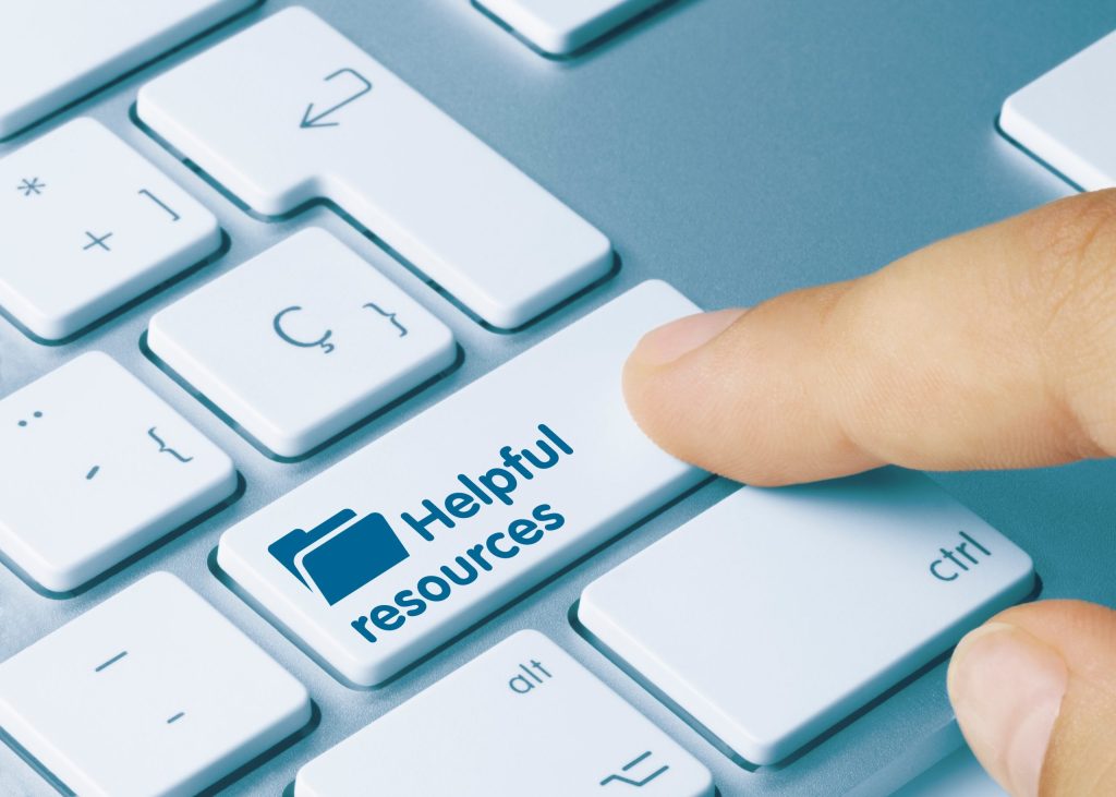 Finger pushing keyboard button that says helpful resources